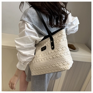 Detail of white crochet tote bag featuring floral patterns and black leather straps