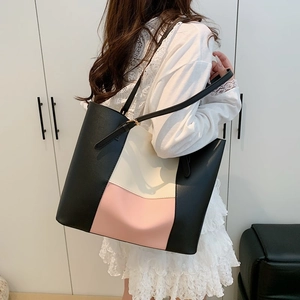Large color-block tote bag in black, cream, and pink with adjustable gold buckles