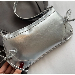 Detail der silbernen Crescent Bag mit Metallic-Falten, Schleife und Y2K-Nieten