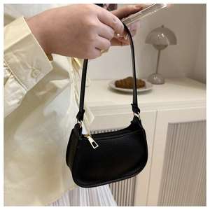 Close-up of black lychee grain leather underarm bag with gold metal zipper and D-ring