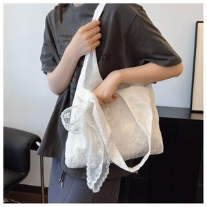 Close-up of white lace tote bag featuring floral embroidery and sweet bow shoulder strap