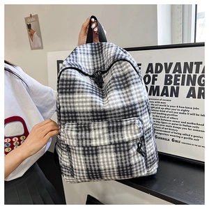Close-up of stylish black and white checkered canvas backpack with zip pocket detail