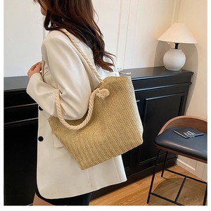 Detail view of woven straw tote bag featuring herringbone texture and jute rope handles