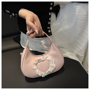 Dettaglio della borsa hobo rosa con decorazione in pizzo a cuore e texture in pelle liscia