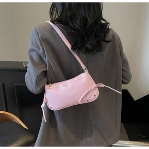 Detailansicht der rosa Lacktasche mit Schleifen und silbernen Nieten an der Schulter