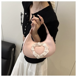Borsa hobo rosa con motivo a cuore e pizzo bianco mostrata indossata da una modella