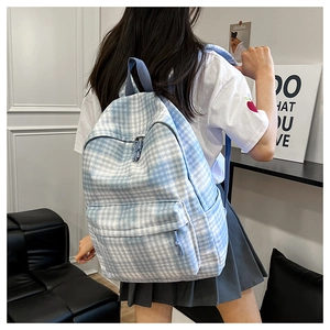Detail shot of the blue and white checkered canvas backpack on a person for daily use