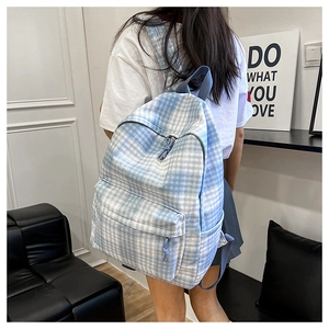 Detail of blue and white checkered backpack featuring front zipper pocket and side pockets