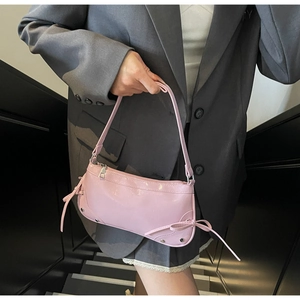 Detailansicht der rosa PU-Lederhandtasche mit Silbernieten und dekorativen Schleifen