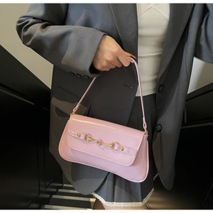 Vue détaillée d'un sac baguette rose avec boucle mors dorée sur un cuir synthétique texturé