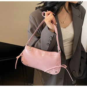 Details der glänzenden rosa Lackleder-Halbmondtasche mit silbernen Nieten und Schleifendekor