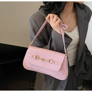 Vue détaillée d'un sac baguette en cuir verni rose avec boucle mors de cheval dorée chic
