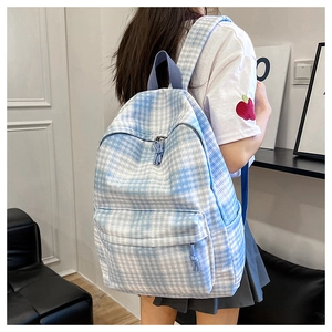Detailed back view of a blue and white checkered large capacity backpack on a model