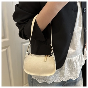 Detail of off-white lychee texture underarm bag with gold zipper and thin shoulder strap