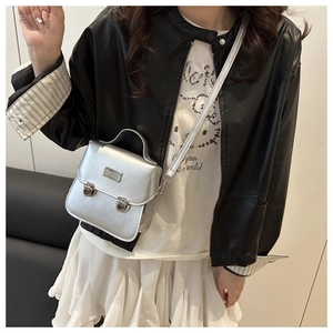 Silver mini square crossbody bag with dual buckles shown in a stylish model street style view