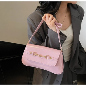 Détail du sac baguette rose brillant avec boucle mors de cheval dorée iconique