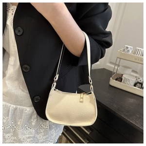 Detailed macro view of cream white lychee-patterned PU leather hobo bag with gold zipper