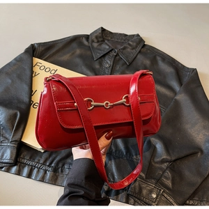 Détail du sac épaule en cuir verni rouge avec boucle mors dorée au style vintage