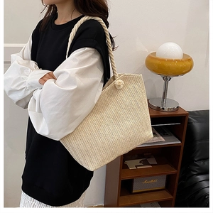 Detail of hand-woven straw tote with thick cotton rope handles for a vacation look
