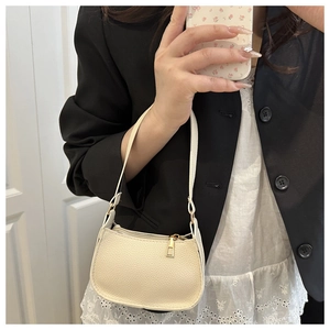 Close-up of beige lychee texture leather underarm bag with gold zipper and slim strap