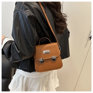 Detailed view of a brown PU crossbody bag with silver hardware and top handle strap