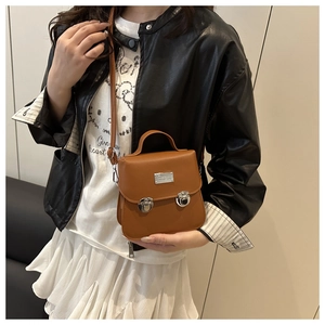 Detail of vintage brown PU leather bucket bag with silver metal plate and buckle