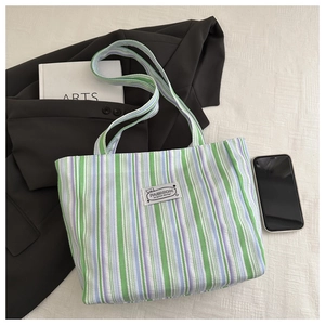 Detail of green and purple striped canvas tote bag showing high-quality fabric and woven label
