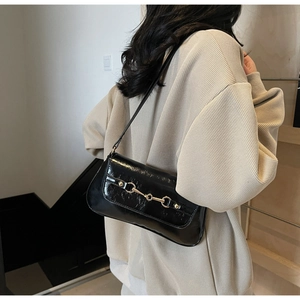 Sac sous l'aisselle en cuir verni noir brillant avec boucle mors dorée rétro