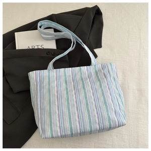 Close-up of blue and purple striped canvas tote bag texture with matching shoulder strap