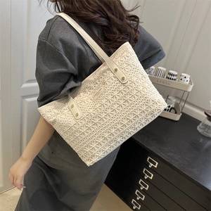Chic cream white woven tote bag with leather handles and gold studs shown on a model