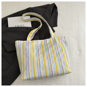 Close-up of vibrant striped canvas tote bag with yellow, blue, and purple vertical pattern