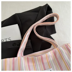 Detail of colorful striped canvas tote showing thick handles and high-capacity texture