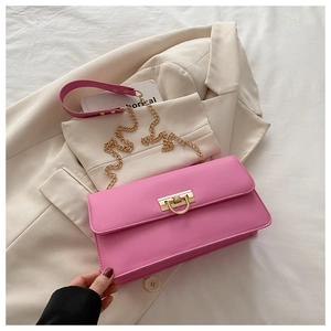 Détail du sac baguette rose vif avec bandoulière chaîne dorée et fermoir anneau