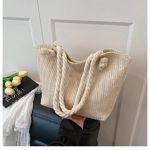 Detail of beige straw tote bag with herringbone weave and thick cotton rope handle