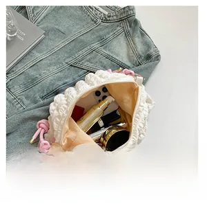 Detail view showing large interior capacity of the white pleated cloud bag with pink knot