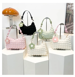 Detail of multi-color bubble textured shoulder bags with woven handles and flower charms