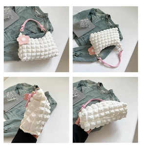 Detail shots of pleated cream crossbody bag with pink woven handle and floral charm