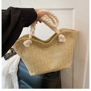 Detail of hand-woven straw tote with white cotton rope handles and herringbone pattern