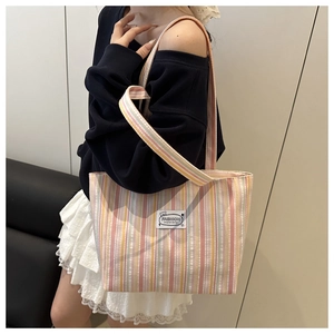 Detail of colorful striped canvas tote bag showing fashion tag and woven fabric texture