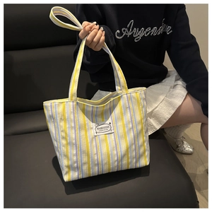 Detail of colorful striped canvas tote bag with fashion tag on thick woven fabric