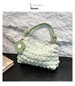 Detail of mint green puffy shoulder bag with bubble texture and floral charm decoration