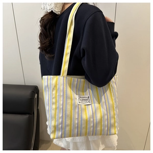 Detail of colorful striped canvas tote bag with fashion original design patch