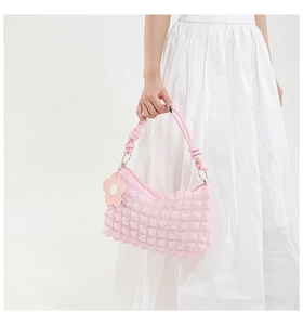 Detail of pink bubble texture shoulder bag featuring a floral charm and zipper closure