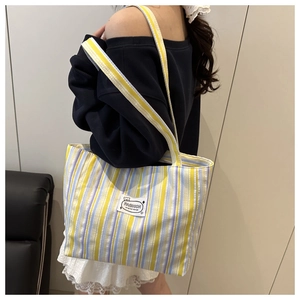 Close-up of stylish large canvas tote bag with yellow and purple vertical stripes
