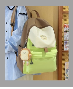 Side view of cream and green color-block backpack with a cute toast plush pendant