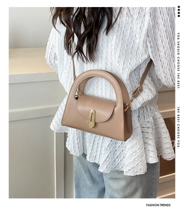 Detailansicht der khakifarbenen halbrunden Handtasche mit goldener Schnalle