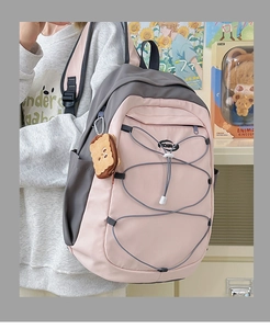 Vue détaillée du sac à dos scolaire rose et gris avec cordons et pendentif en peluche