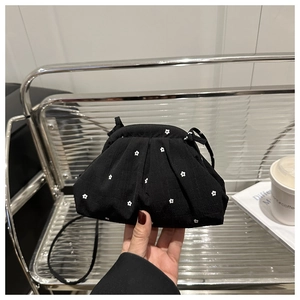 Détail du sac nuage noir à motif floral blanc avec une texture plissée