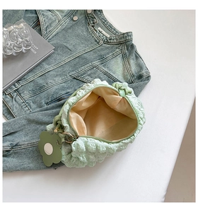 Detail of light green bubble texture shoulder bag with cute floral charm accessory