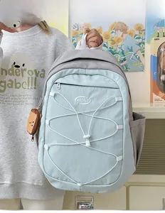 Détail du sac à dos en nylon bleu clair avec cordons blancs et breloque toast mignonne